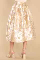 Back view of  this skirt that features a high waist, raised gold flower details, waist pockets, a hemmed bottom, and a back zipper closure.