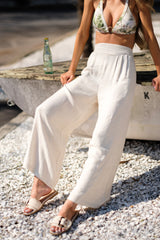 These taupe pants feature a high waisted design, an elastic insert in the back, functional hip pockets, a lightweight fabric, and a wide leg design.