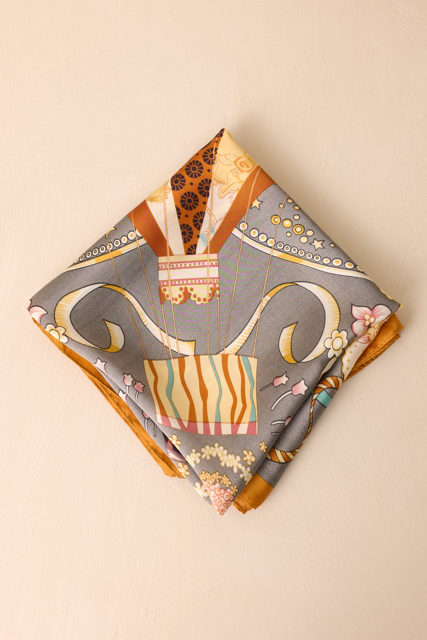 Another folded view of the hair scarf showing the slate gray background and colorful balloon pattern.