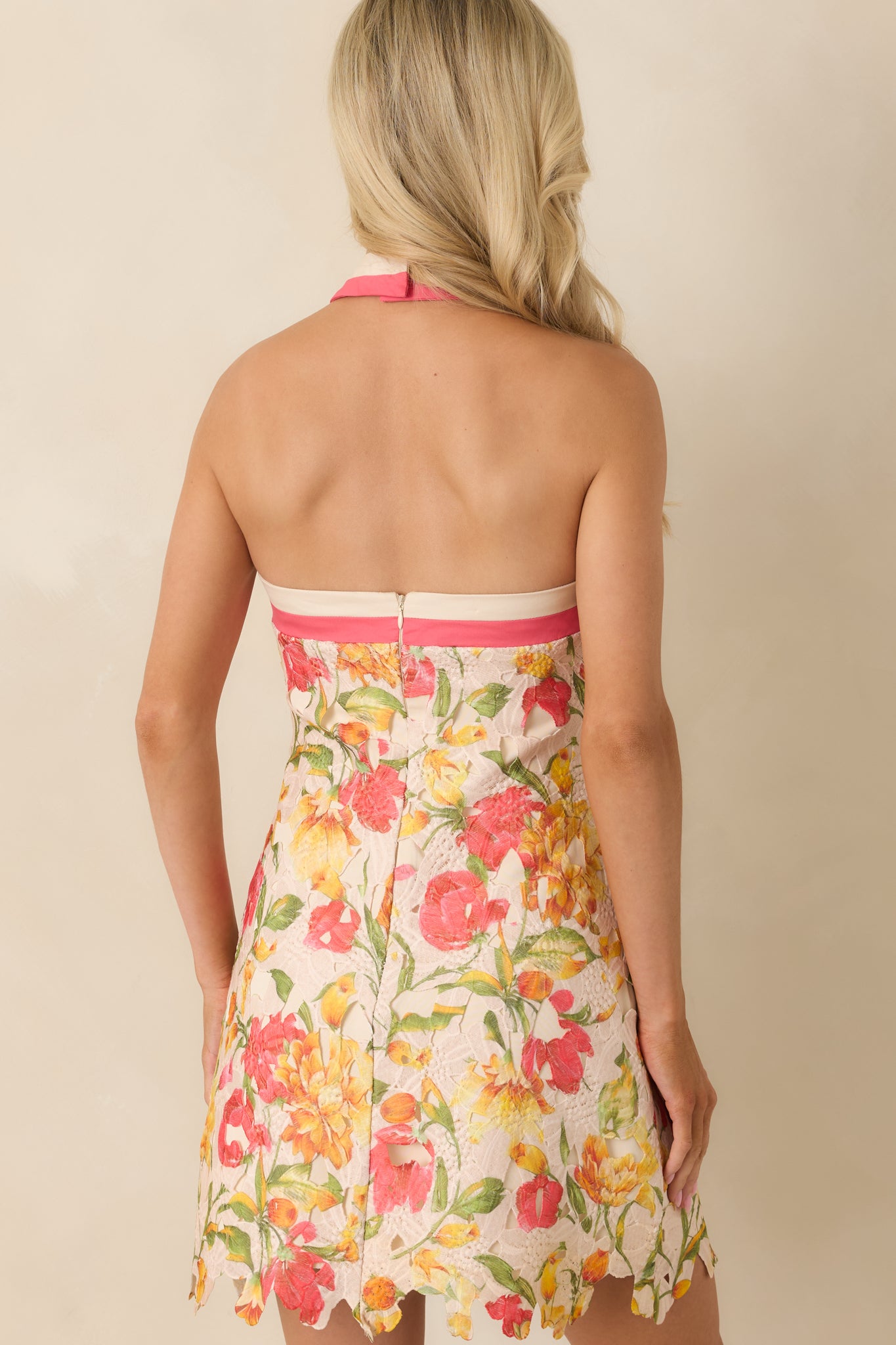 Ivory floral lace mini dress from the back, featuring a concealed zipper closure and a clean A-line silhouette beneath the lace overlay.