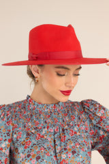 This all red hat is a stiffened wool fedora complete with rigid crown design and a trimmed on hat and rim with tonal gross grain ribbon.