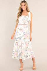 Front view of this ivory floral midi dress that features a square neckline, self-tie straps, a hidden zipper down the back, a single-tier design, and a lace knitted overlay.