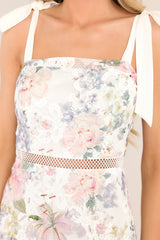 Close up of the lace floral bodice, ribbon straps, and knitted waist overlay on this ivory floral midi dress.