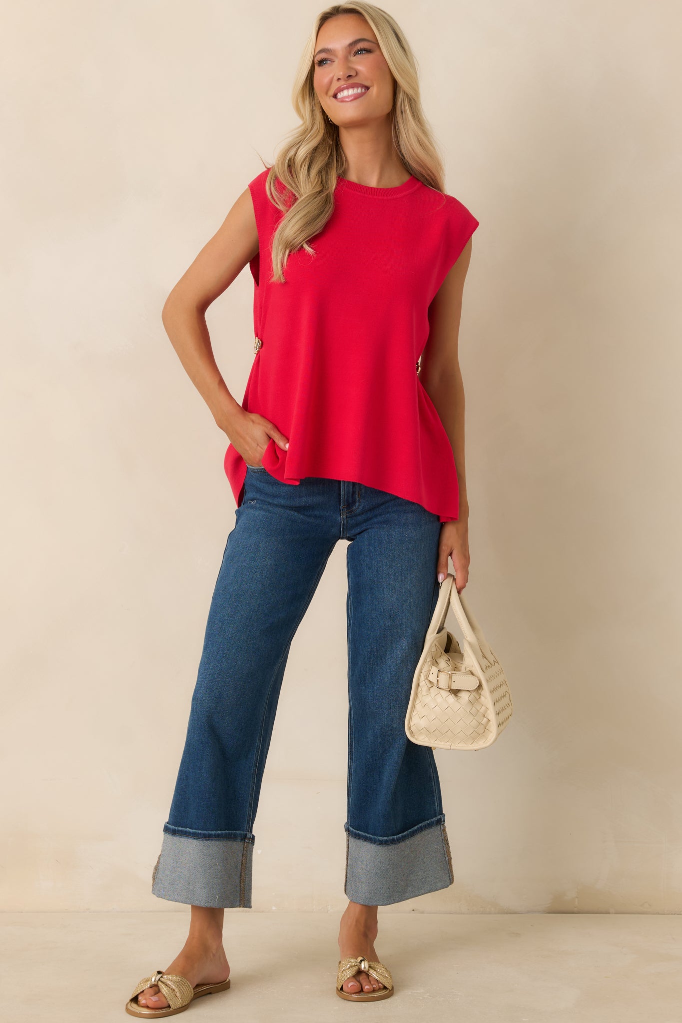 Red sleeveless top with gold side hardware detailing and an asymmetrical hemline.