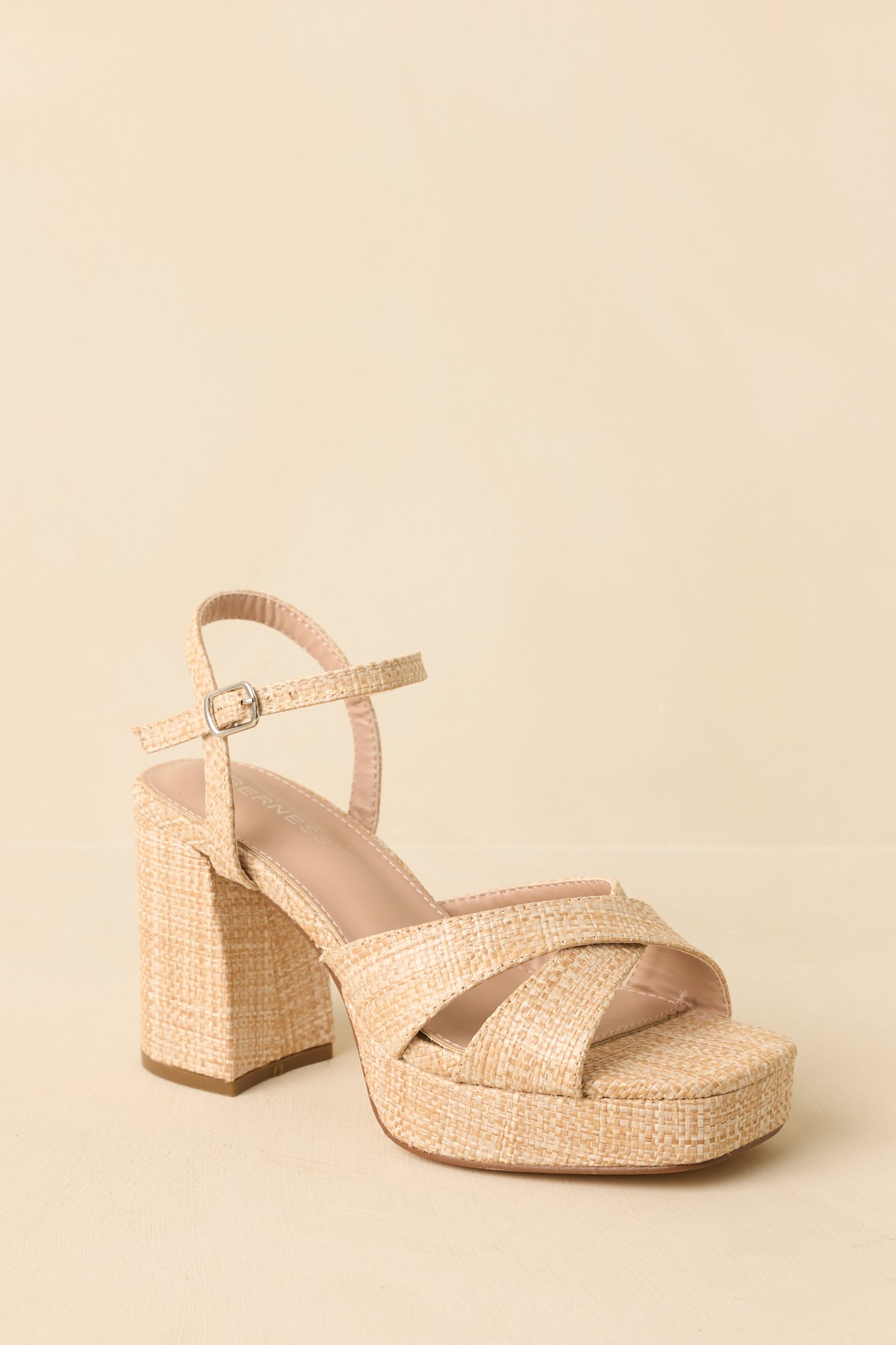 Sandals angled to highlight the ankle strap buckle and clean platform silhouette.