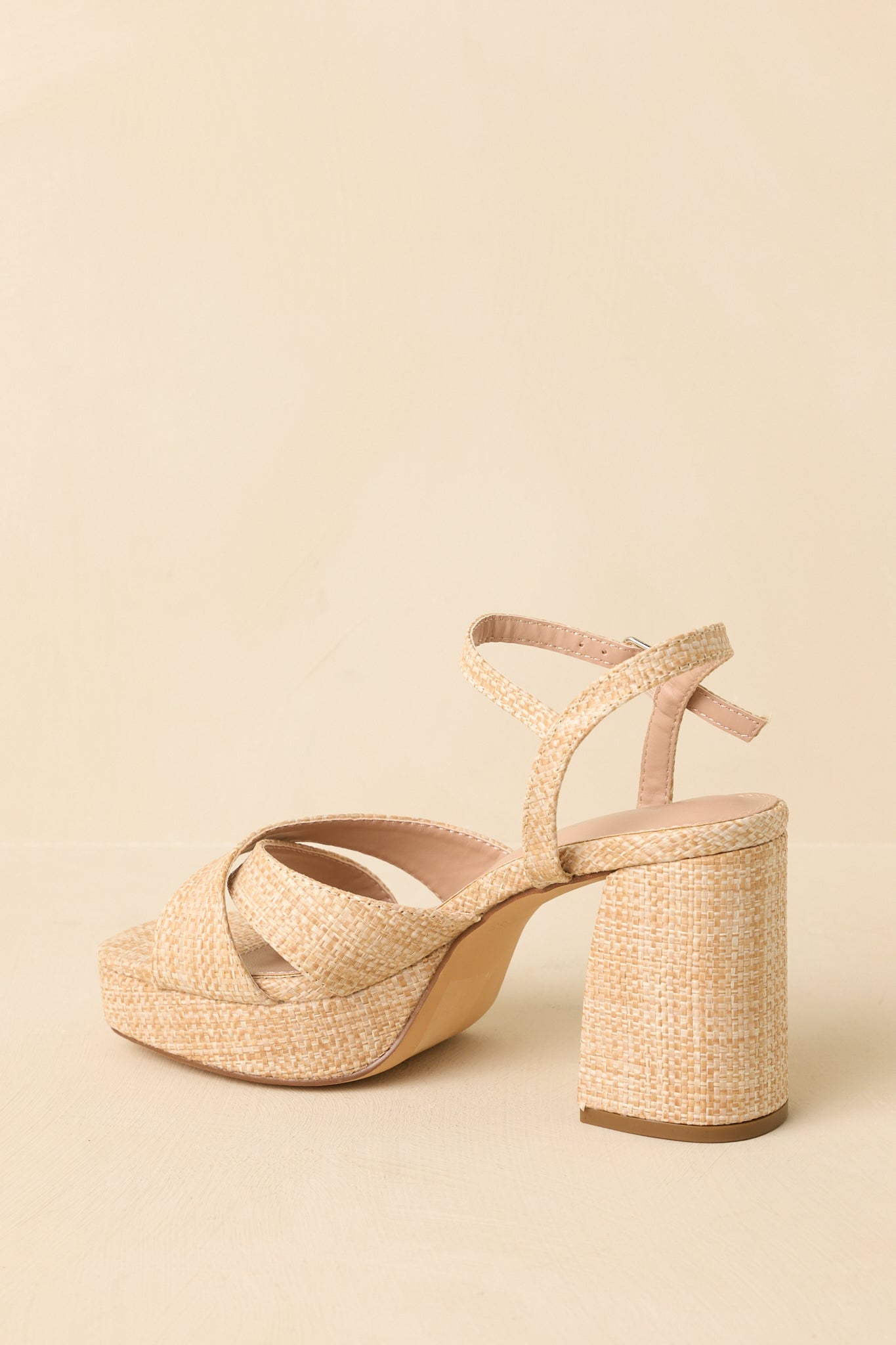 Sandals angled to highlight the ankle strap buckle and clean platform silhouette.