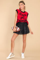 Full body view of this sweater vest that features a crew neckline, shiny football sequins, 