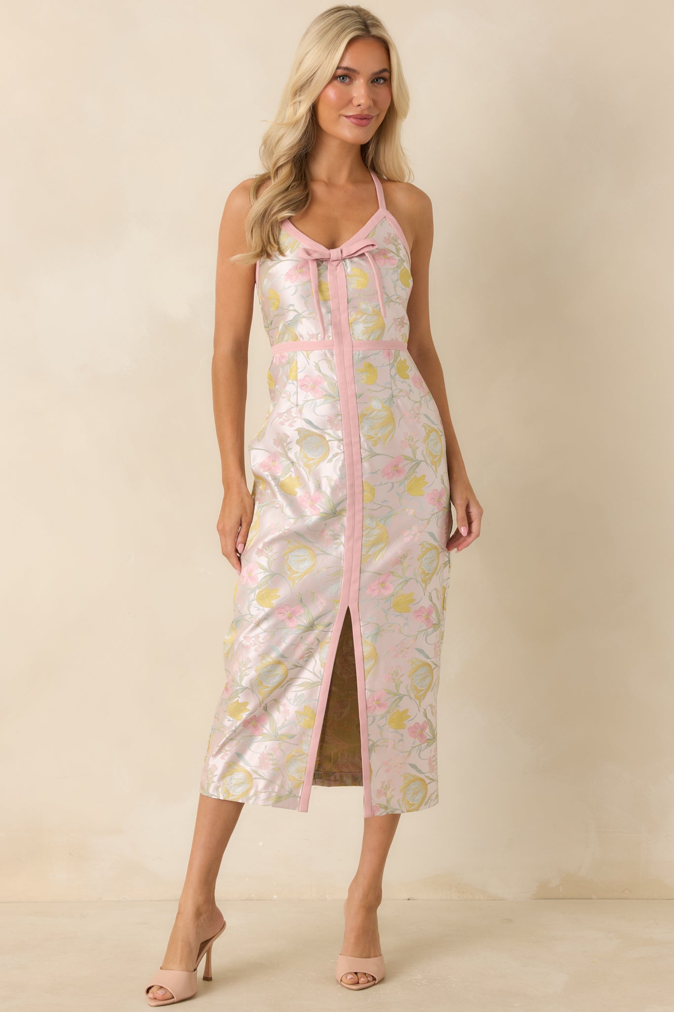 Pink floral midi dress showcasing a fitted shape, contrast trim accents, and a graceful front slit that enhances the streamlined silhouette.