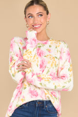 This ivory sweater features a crew neckline, an all over floral print, and cuffed sleeves. 