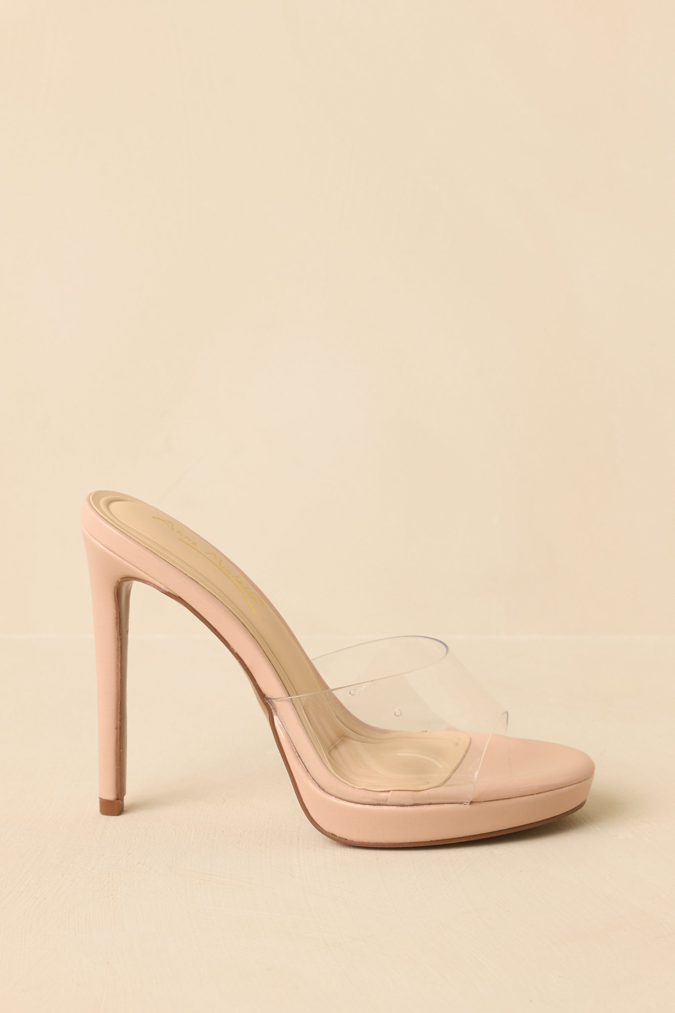 Beige clear stiletto heels displayed from the side to show the full slim heel and open-toe design.