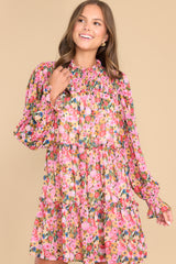 Front view of this dress that features a high neckline, a keyhole cutout at the back of the neck with a button closure, a sheer smocked section at the shoulders, sheer long sleeves with smocked cuffs, and a flowy skirt.