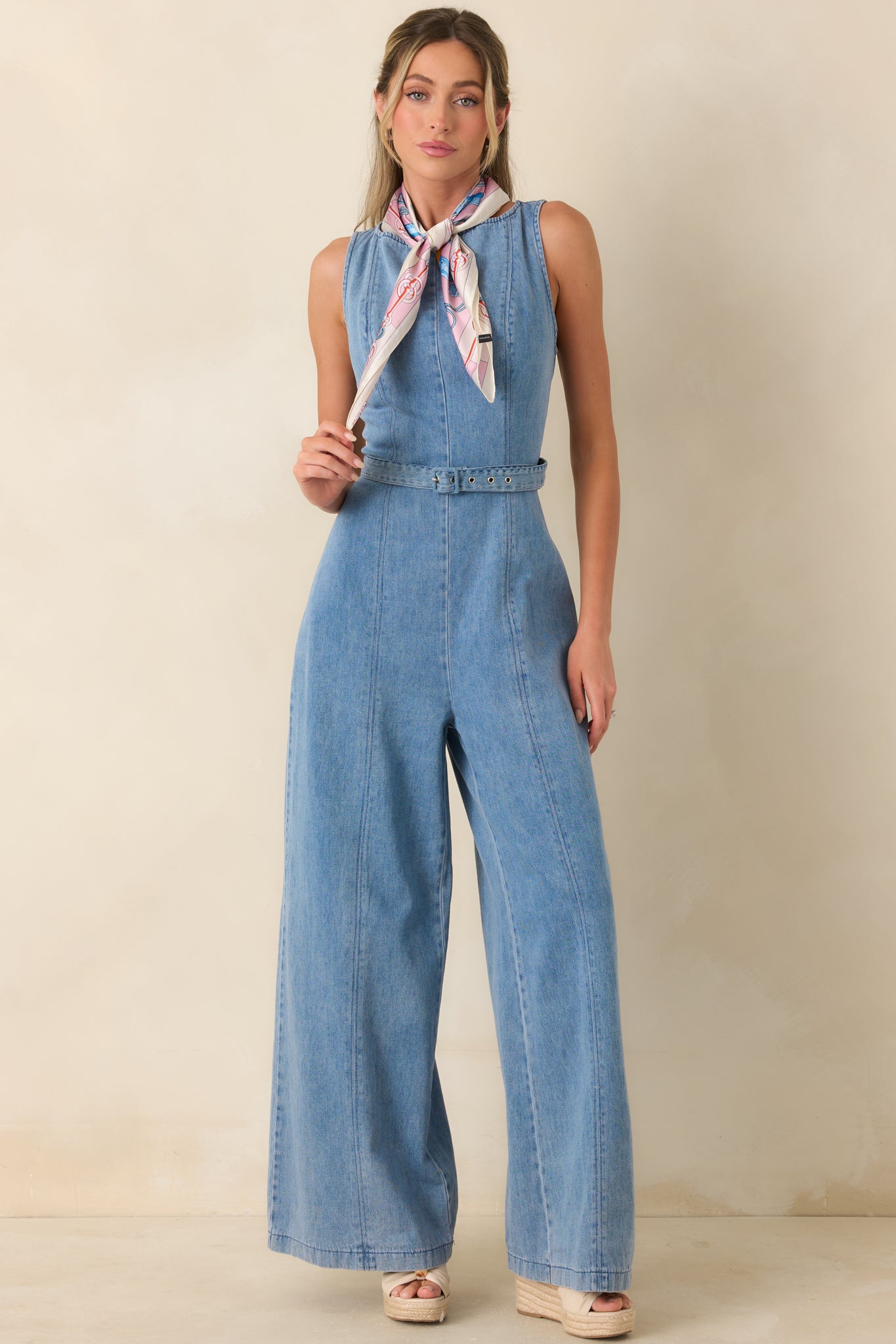 Structured light wash jumpsuit designed with vertical seams and a defined waist for a sleek silhouette.