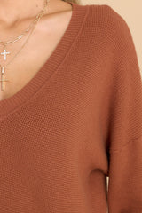 Close up view of this top that features a ribbed V-neckline, a drop shoulder, ribbed cuffs, ribbed hemline, and a waffle knit material.