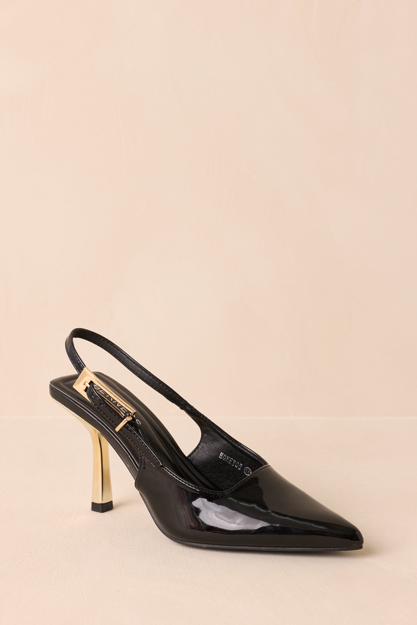 Three-quarter view of black heels showing gold accents and slingback design.