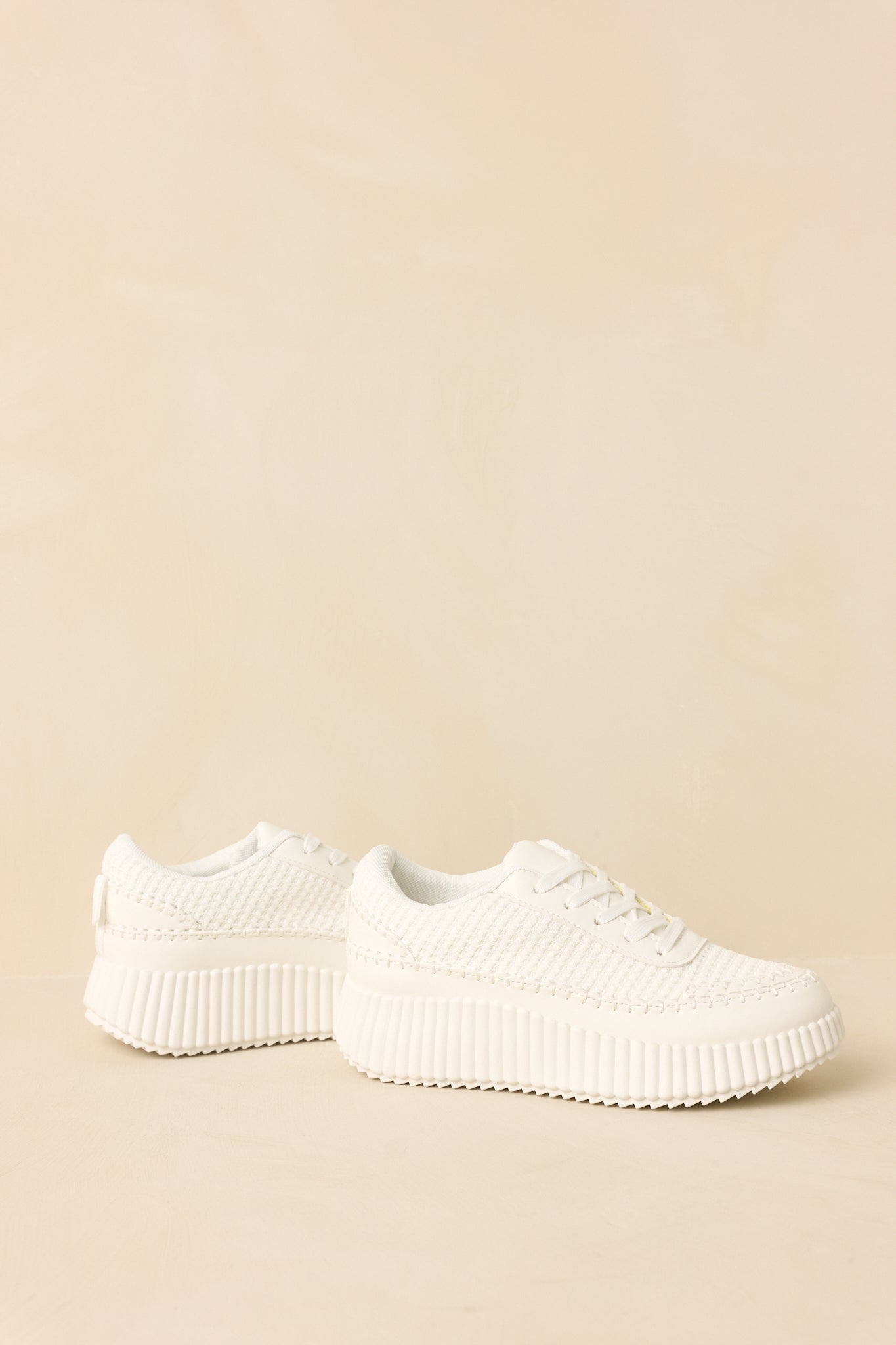 White platform sneakers highlighting the ribbed sole and cushioned interior.