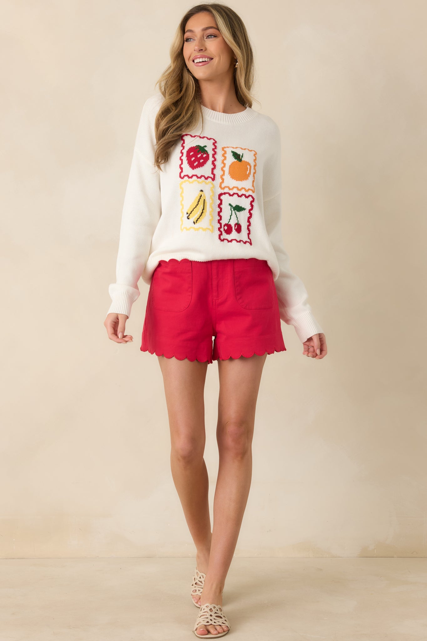 Soft pullover top with playful fruit motifs and vintage-inspired scalloped border accents.