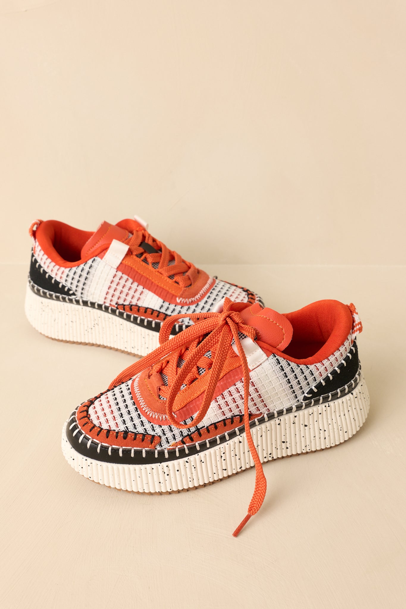 Full view of the orange multicolor platform sneakers highlighting the woven textile upper and lace-up design.