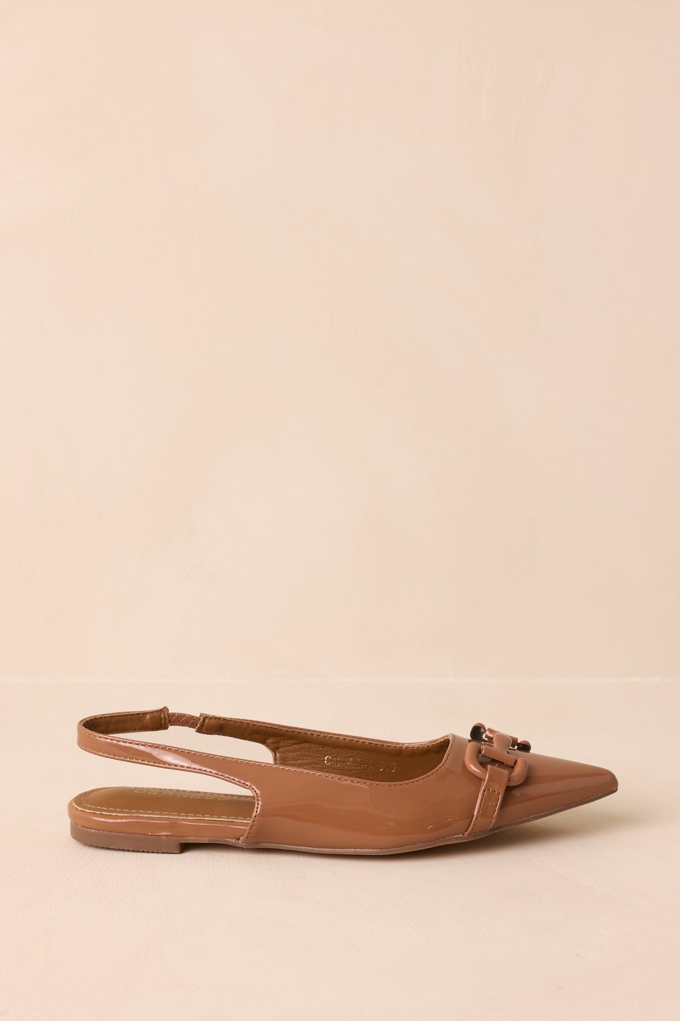 A side profile view of the mocha brown flats against a beige background, emphasizing the elastic slingback and flat sole.
