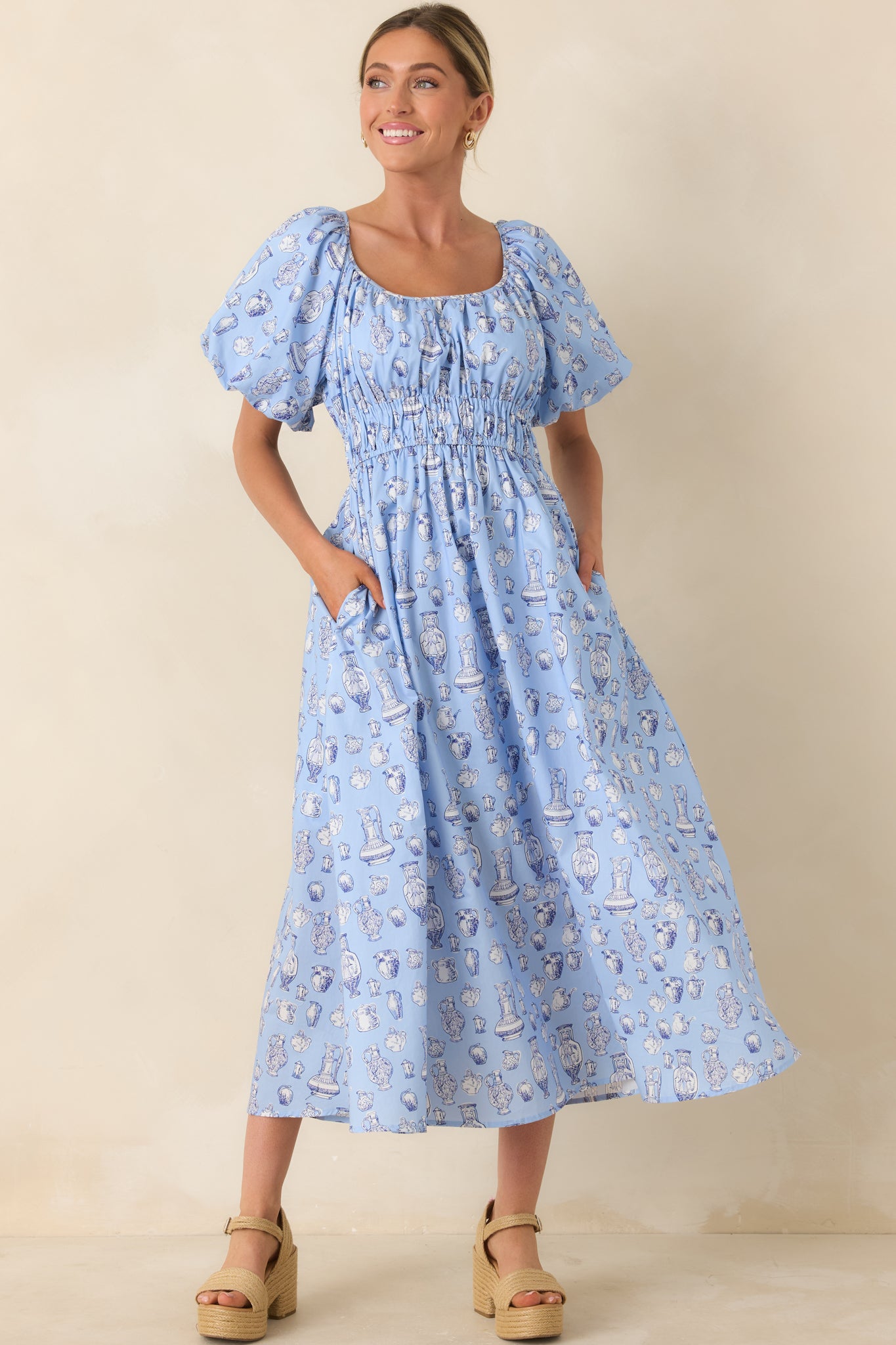 Romantic dress featuring puff sleeves, smocked waist, and flowing midi silhouette.
