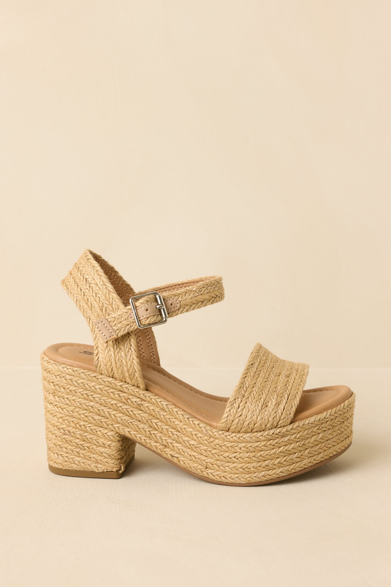 Sandals angled to highlight the ankle strap buckle and platform silhouette.