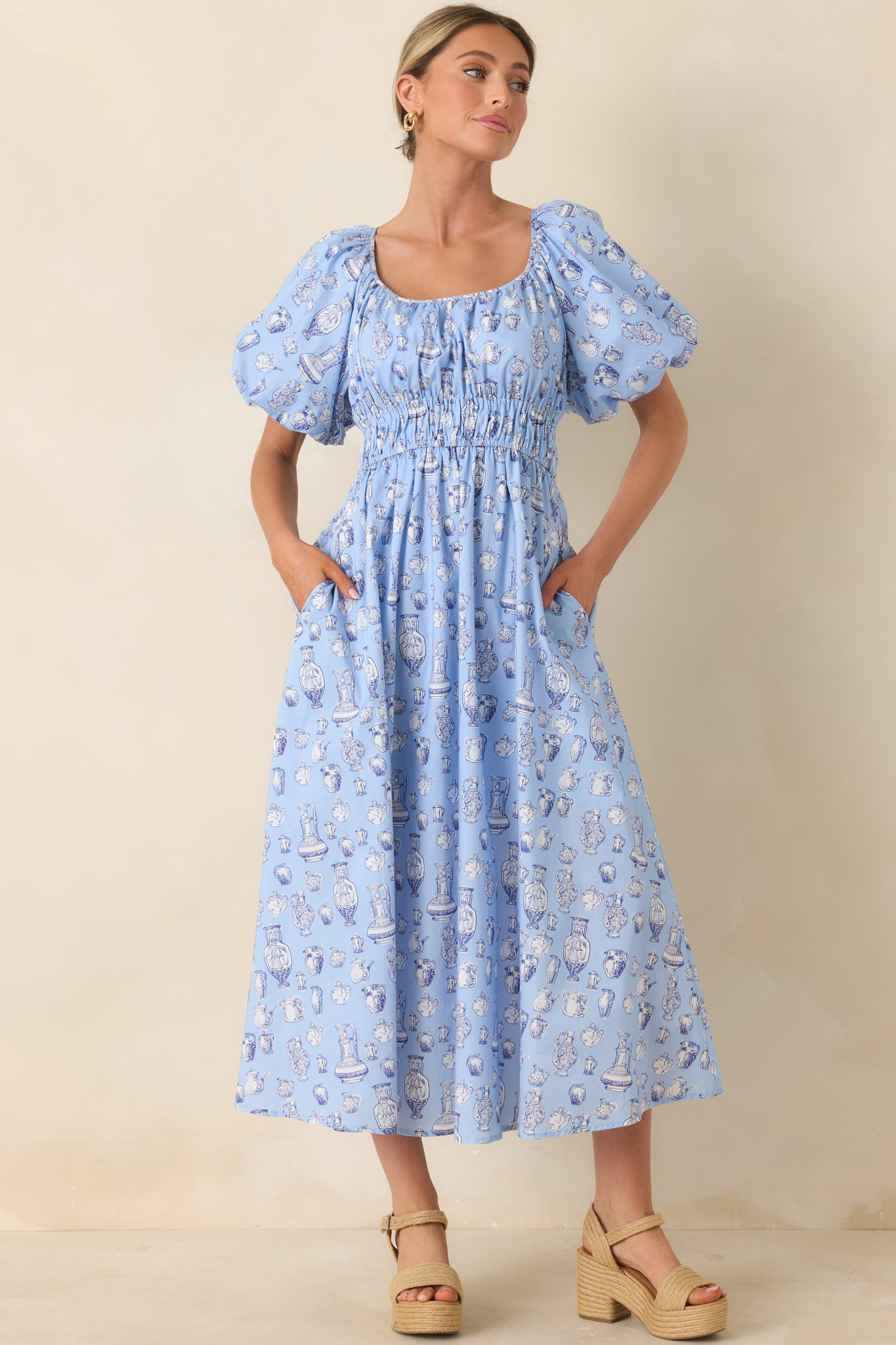Soft blue cotton midi dress with toile-inspired pottery print and gathered neckline.