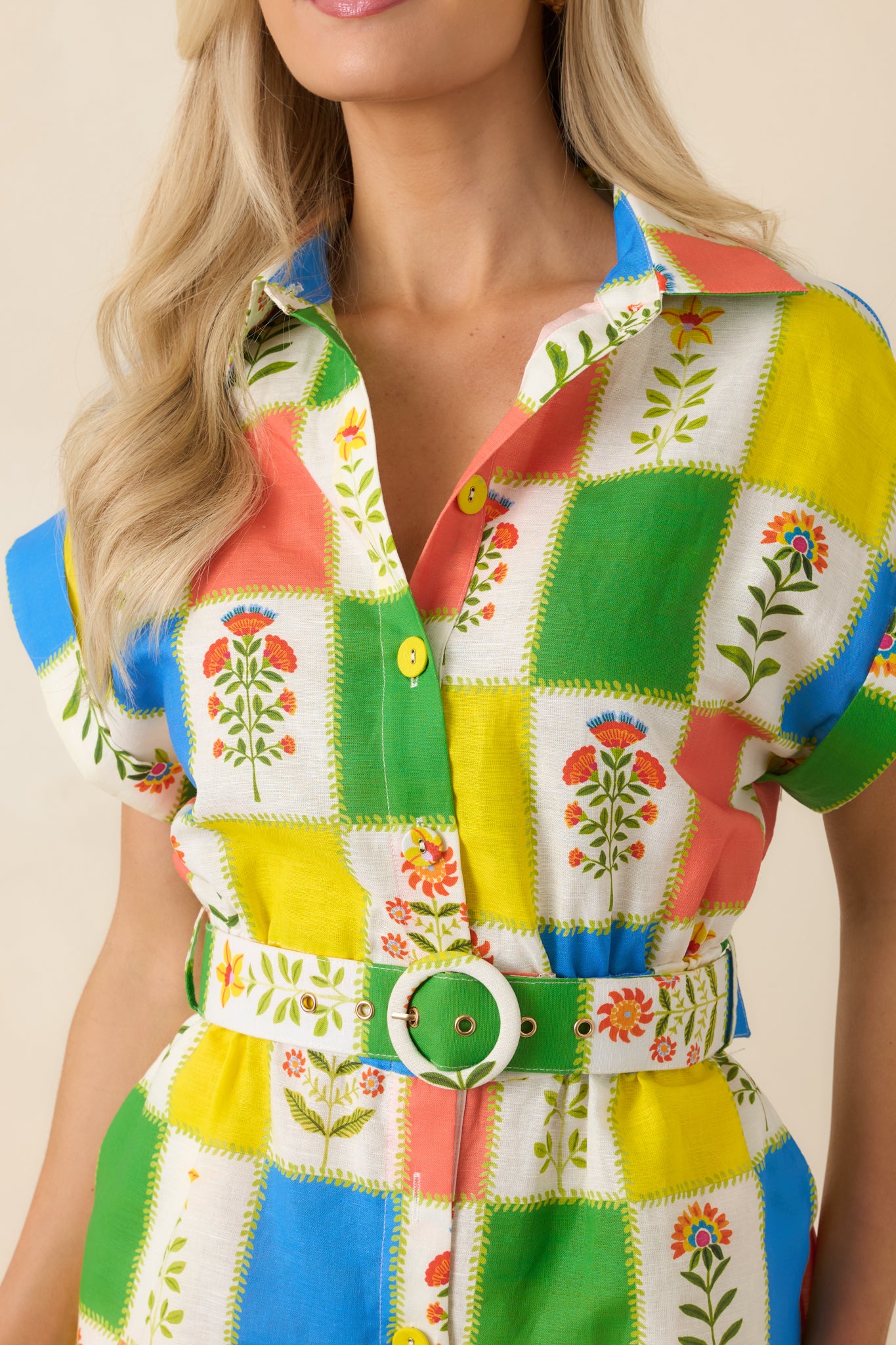 Tight view of the patchwork floral print and button detailing, highlighting the vibrant color variation and softly textured linen-cotton fabric.