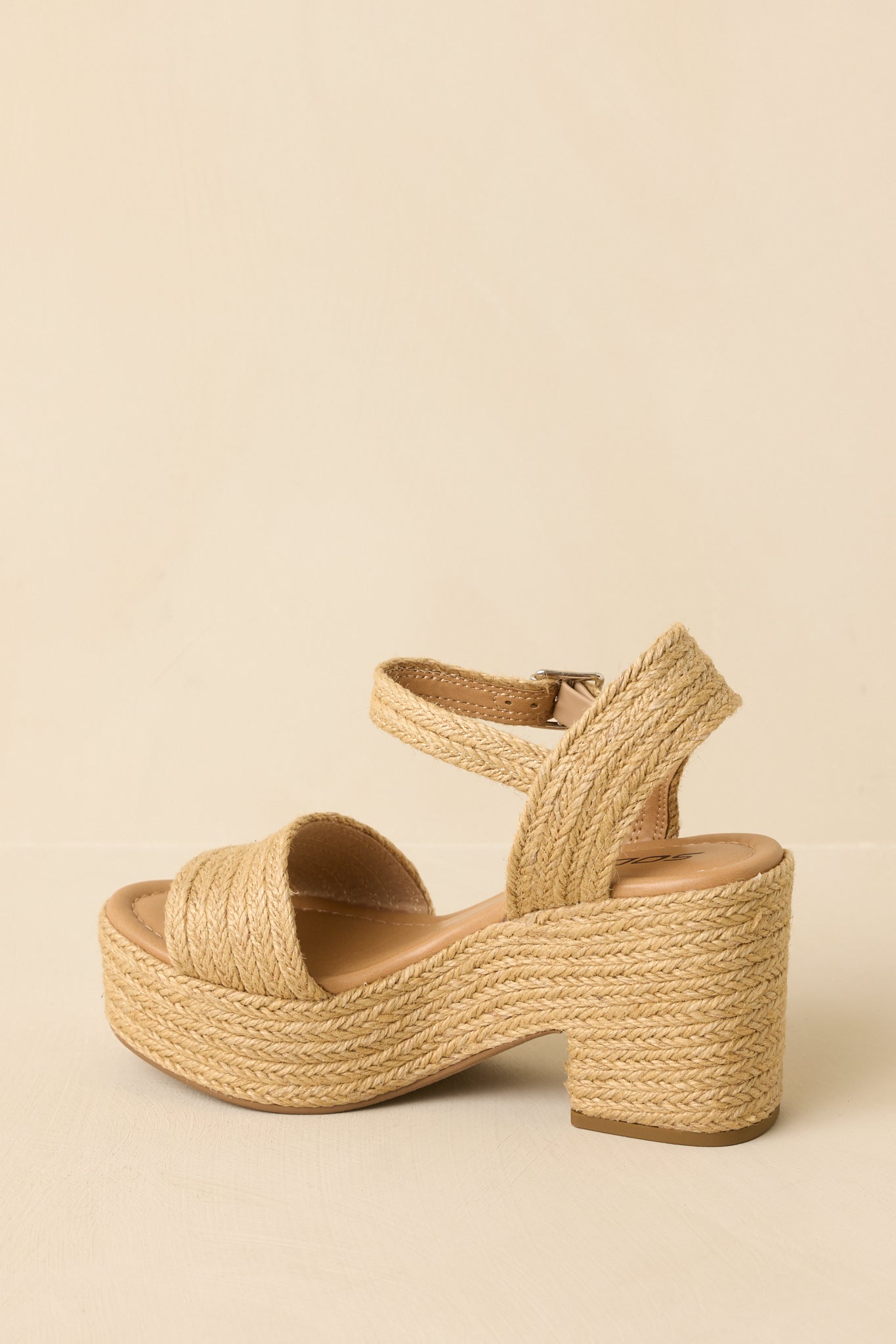 Natural raffia block heel sandals angled to emphasize the woven texture and overall silhouette.
