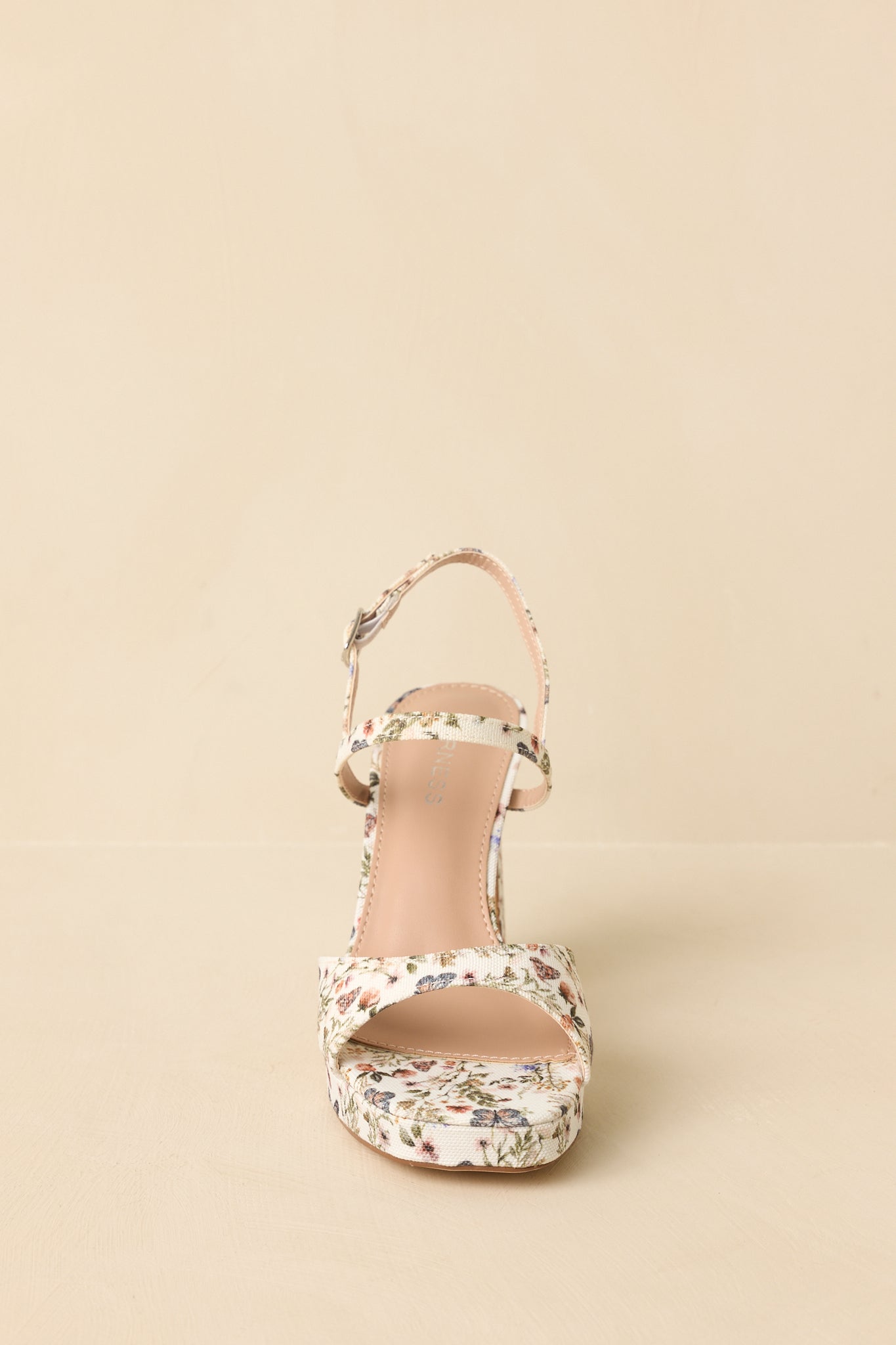 Floral sandals angled to highlight the open-toe design and ankle strap detail.