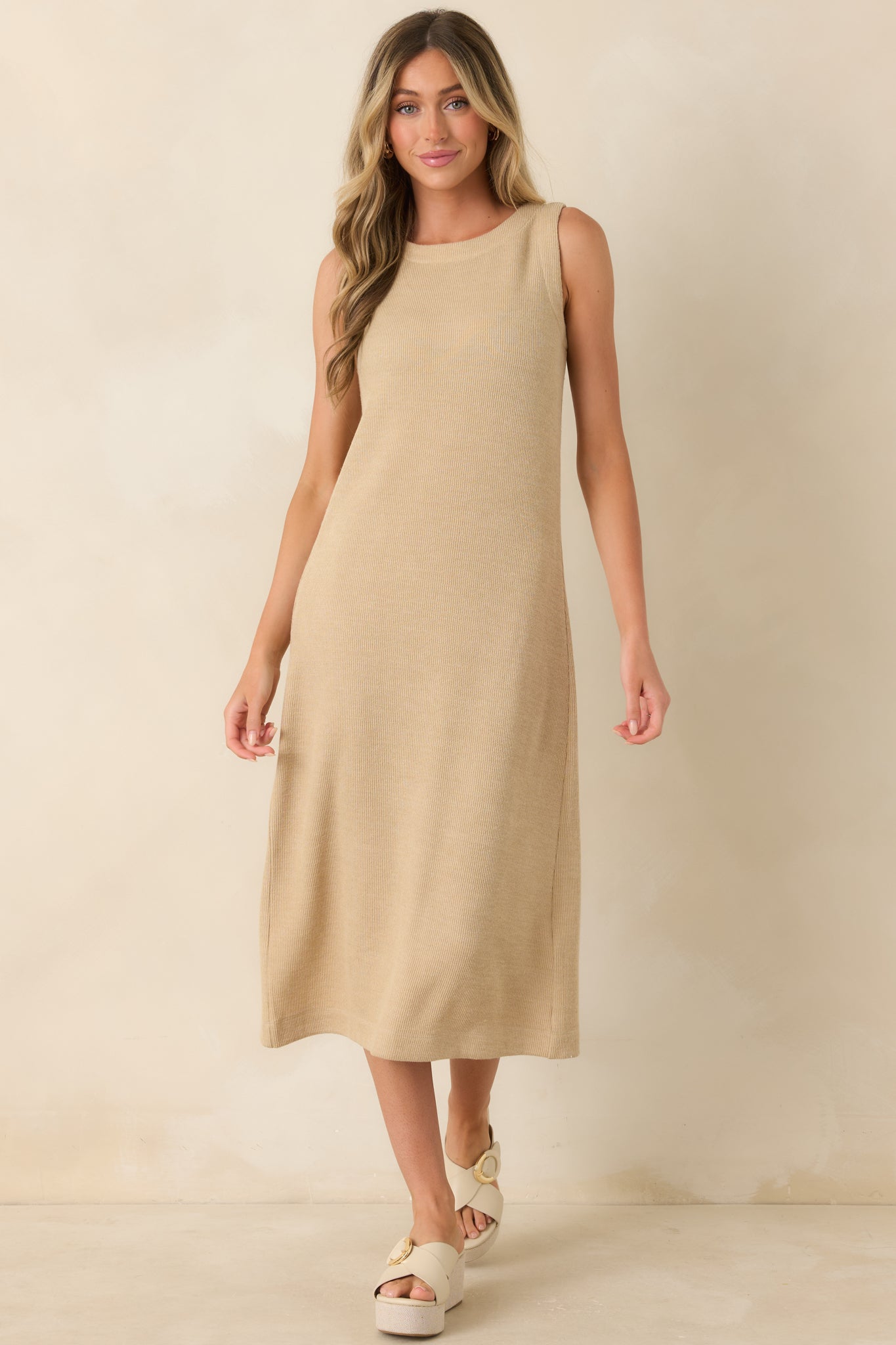 Sleeveless natural midi dress showcasing textured ribbing and an elegant elongated silhouette.
