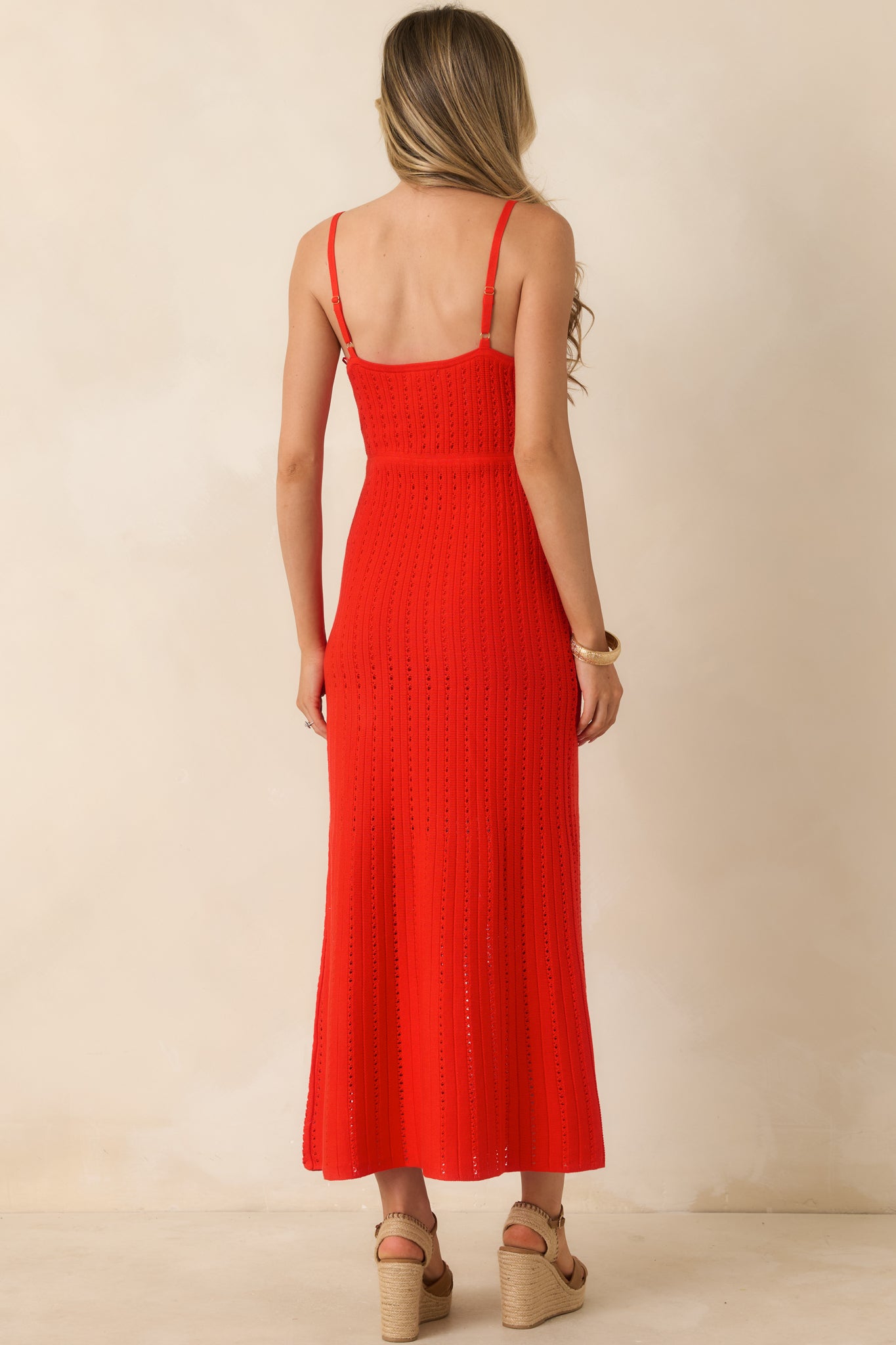 Back view of the poppy red crochet maxi dress featuring the open-knit design, adjustable spaghetti straps, and fitted silhouette.