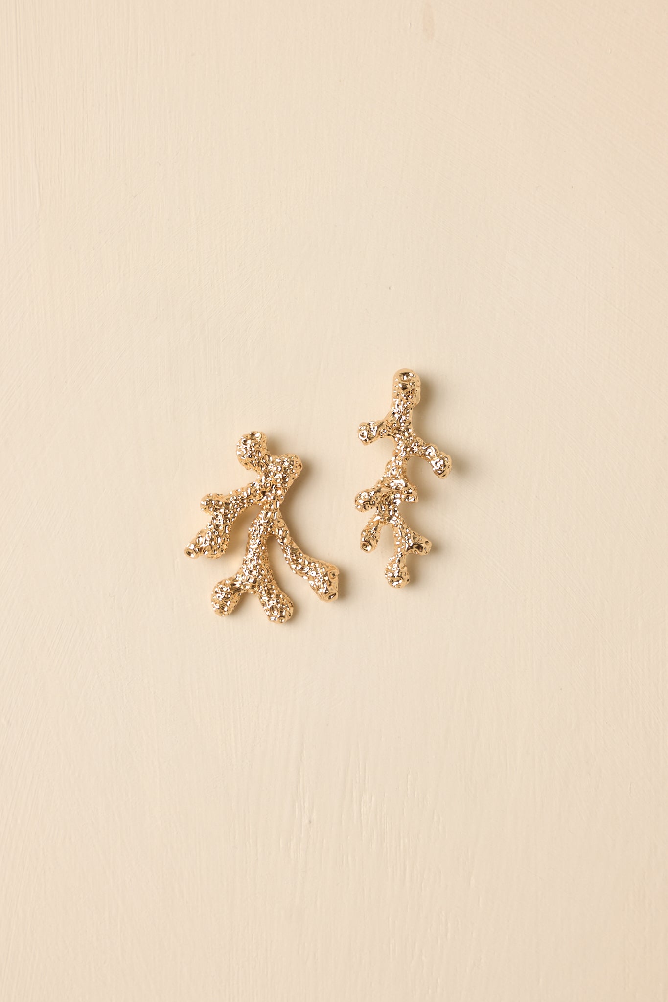 Cropped view of textured gold-tone drop earrings featuring a coral branch–inspired design with an elegant, lightweight silhouette.