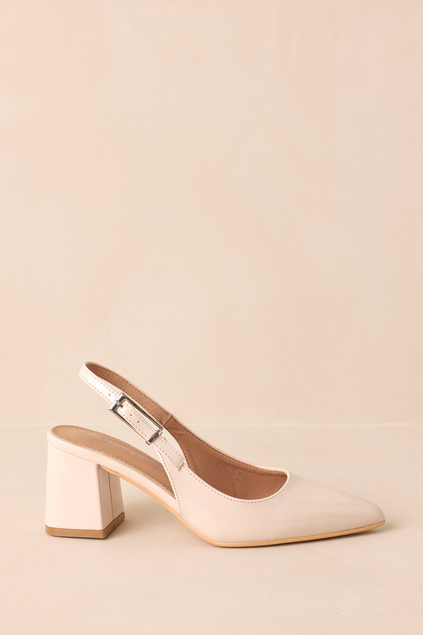 Side view showing glossy beige heels with adjustable slingback strap.