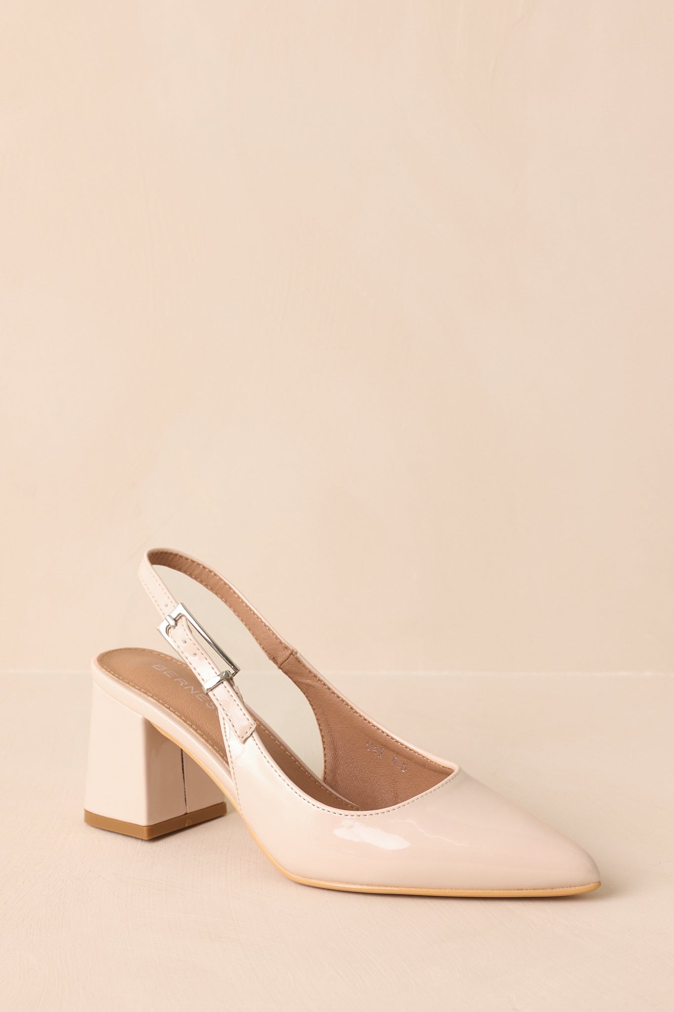 Three-quarter angle highlighting sleek silhouette and structured block heel.