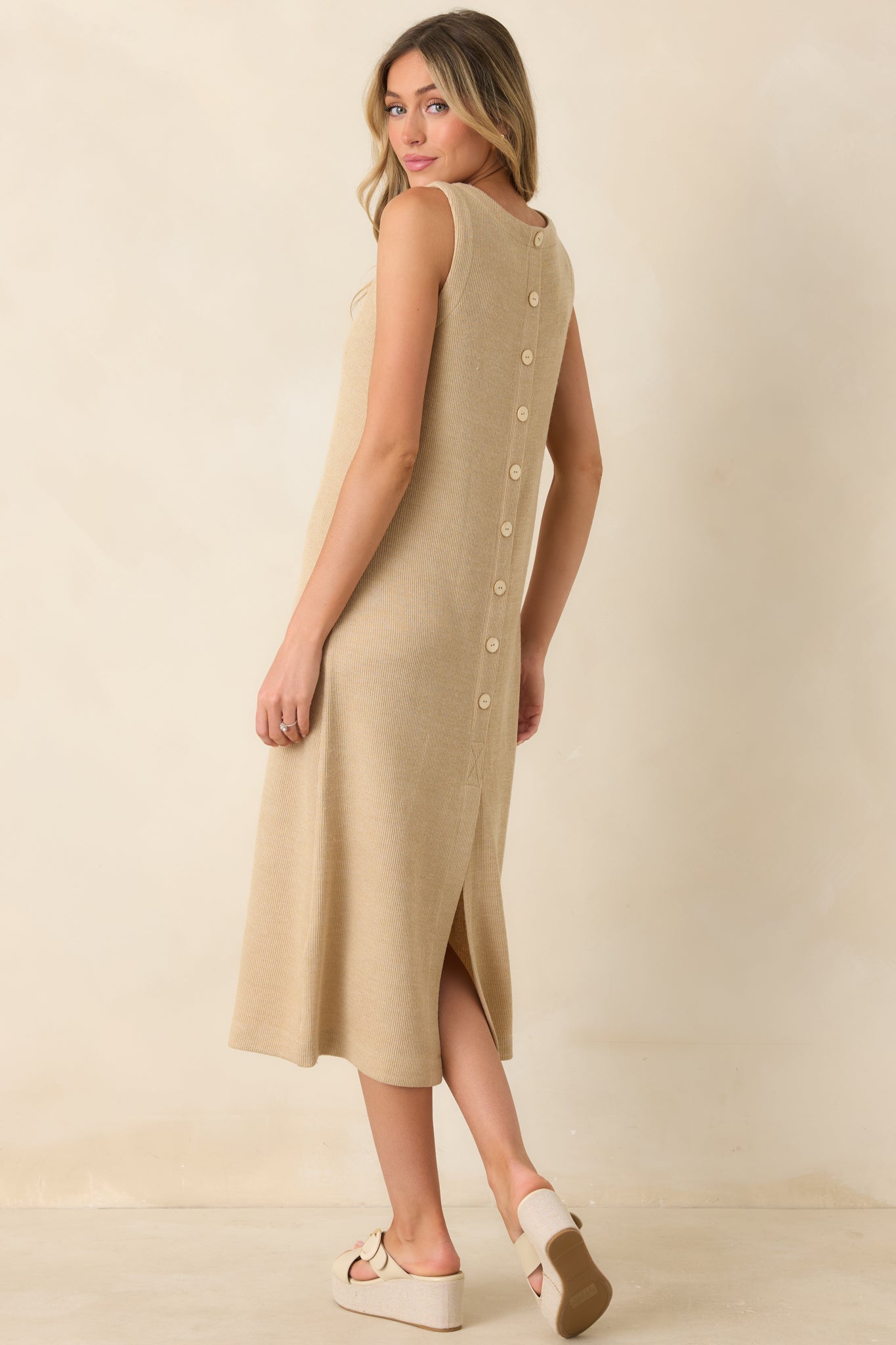 Rear view of the natural midi dress featuring decorative button accents and a back slit hem for added movement.