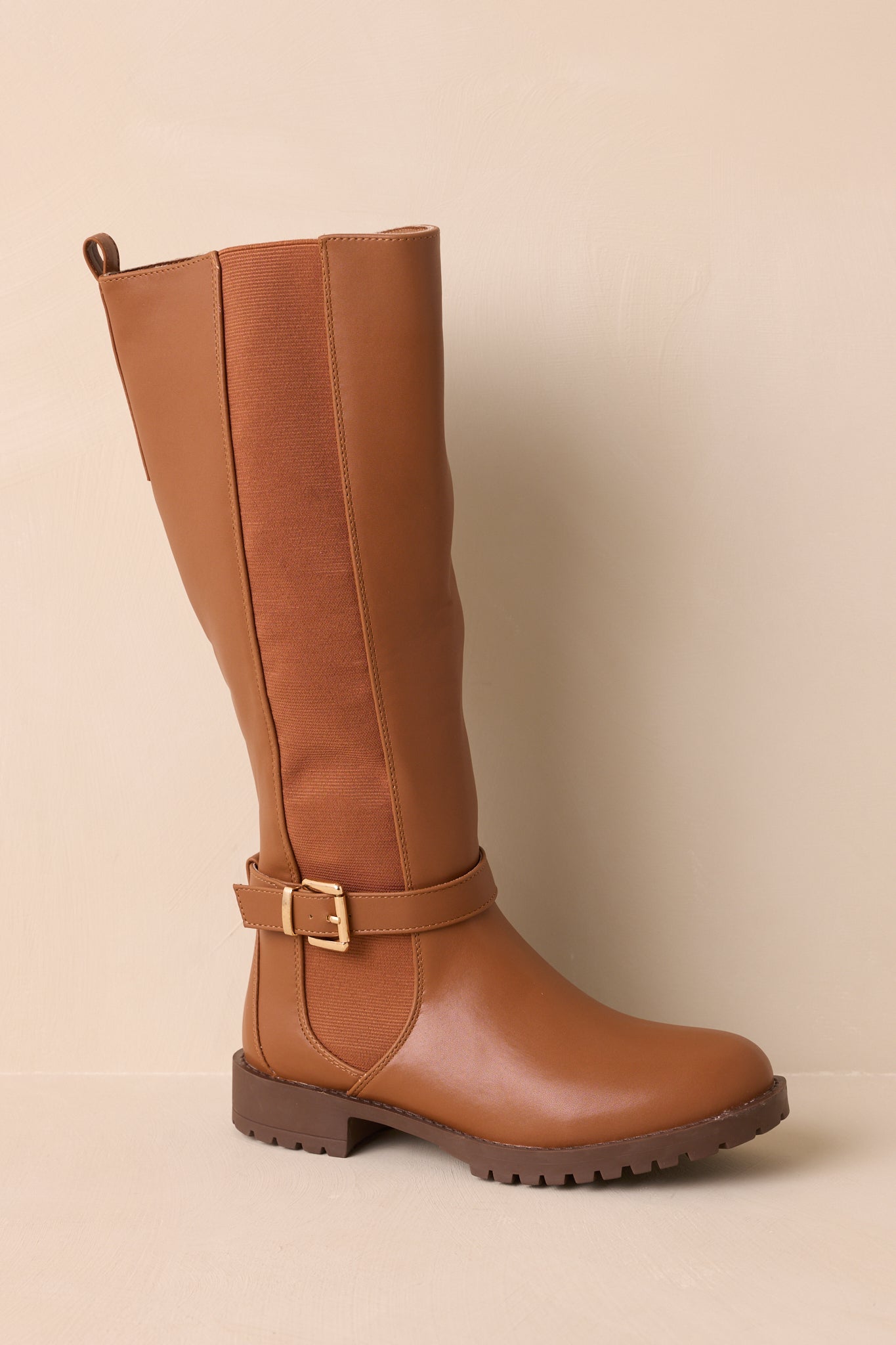 A cropped view of the caramel brown riding boots showing the round toe and low block heel.