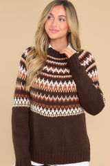 This brown sweater features a crew neckline, a fun fall design, and ribbed hemline and cuffs. 