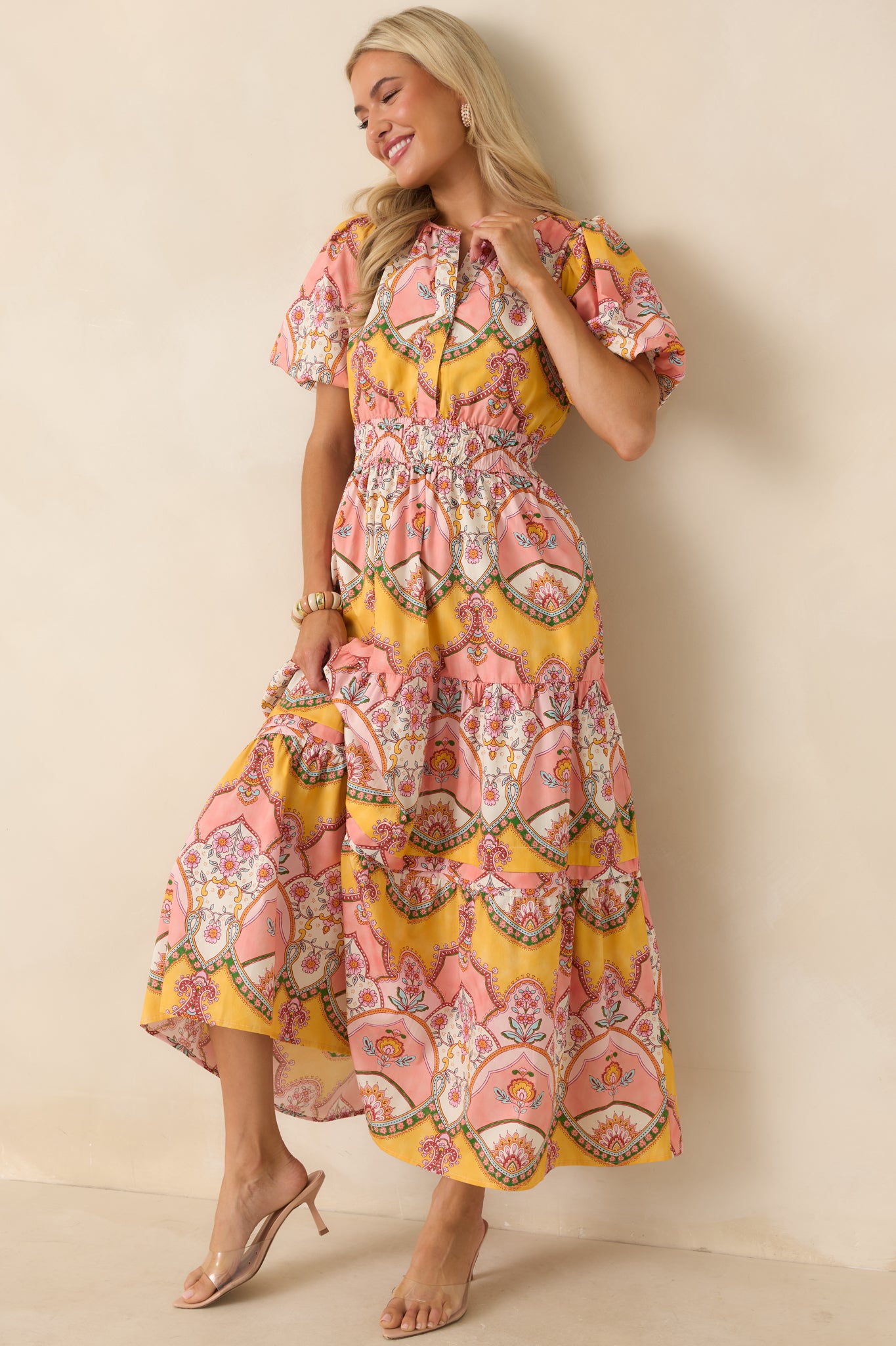 Cotton midi dress showcasing an intricate pink and marigold scarf-print pattern, front snap closures, and an elastic smocked waistband.