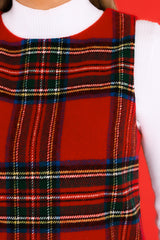 Close up view of this dress that features a round neck and a plaid pattern.