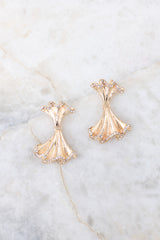 Close-up shot of earrings that feature gold hardware, small rhinestone detailing, and a secure post backing.