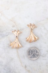 Rhinestone encrusted gold earrings compared to quarter for actual size. Earrings measure 1.5