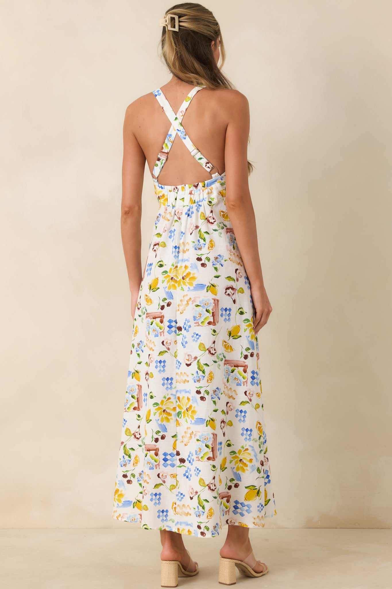 Rear view of multi-print midi dress with cross-back design and open, airy finish.