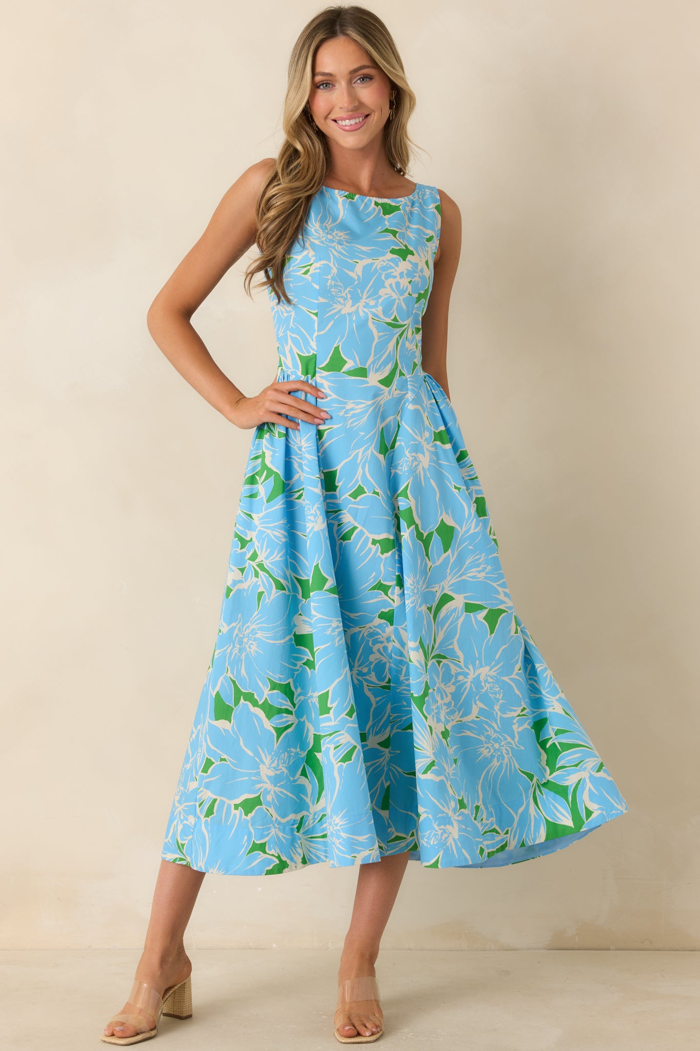 Sleeveless cotton midi dress showcasing a timeless floral pattern, structured fit through the bodice, and a voluminous skirt.