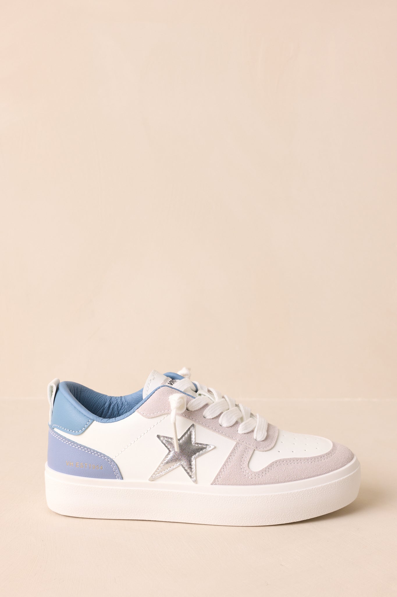 Side angle highlighting the metallic star detail and lace-up closure on the sneakers.