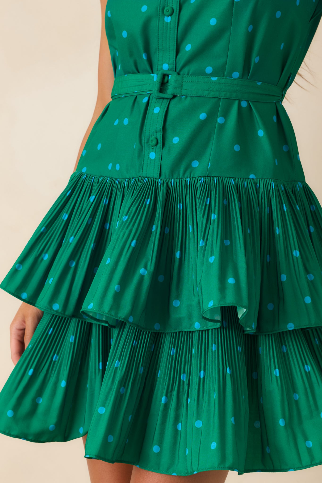 Close-up of the lightweight woven fabric showcasing the green base with contrasting blue polka dot print and clean stitching.