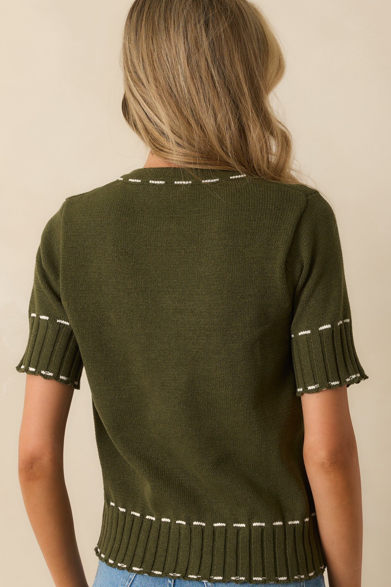 Rear view of the olive green cardigan showing short sleeves and clean stitching lines.