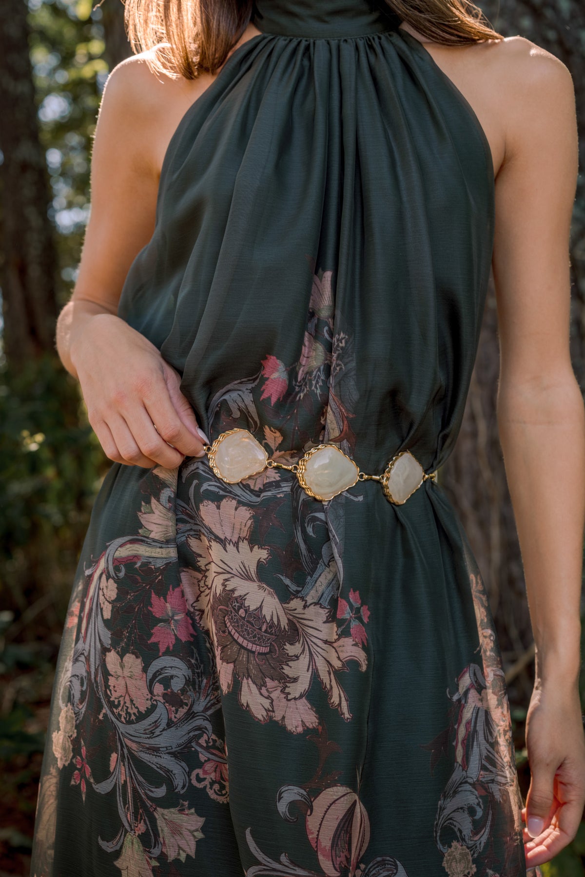 Delicate chain belt with irregular stone-shaped accents and textured metal links, shown draped at the waist.
