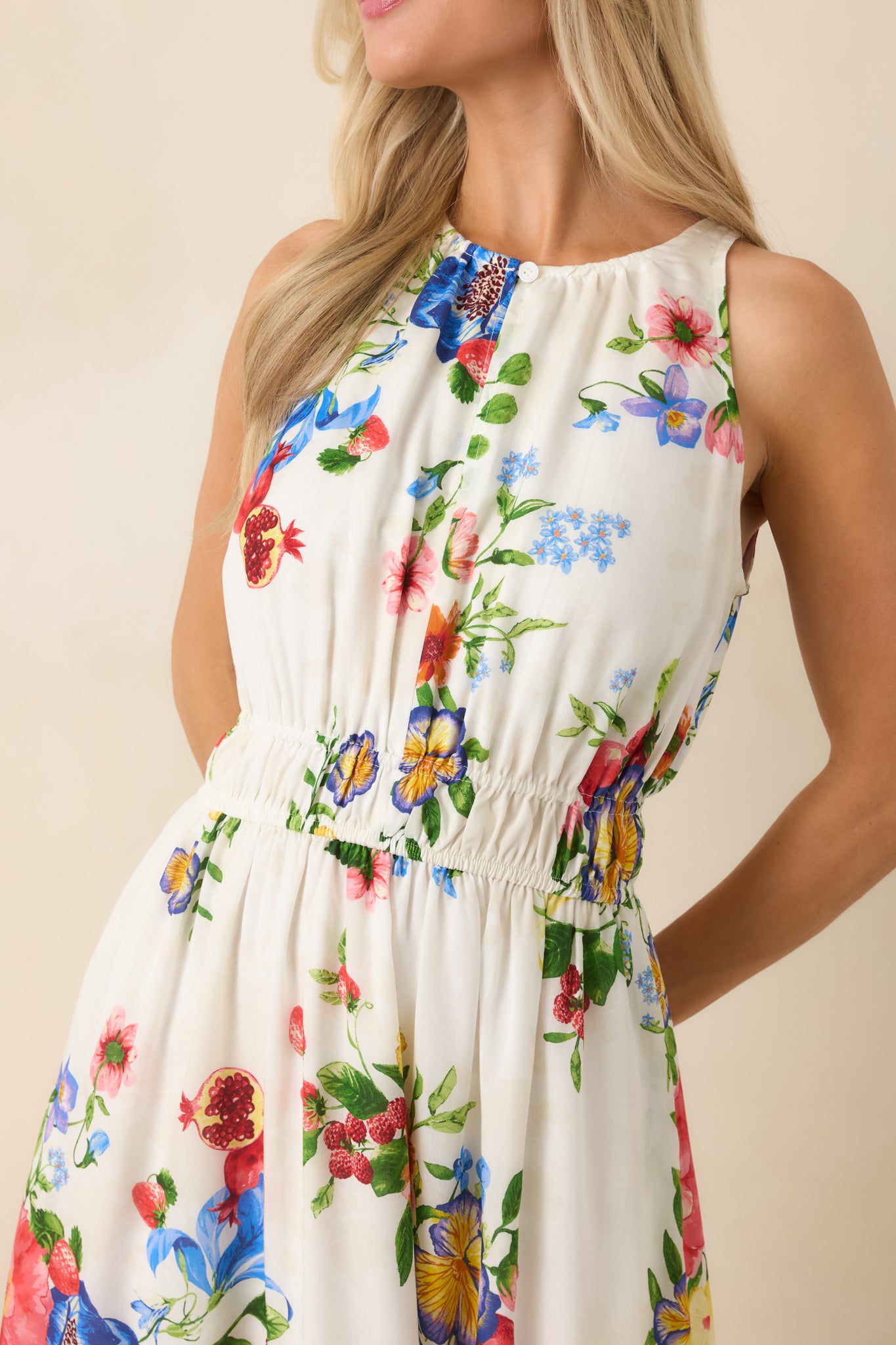 Close-up of colorful floral and fruit-inspired fabric showing gathered neckline and subtle trim detailing.