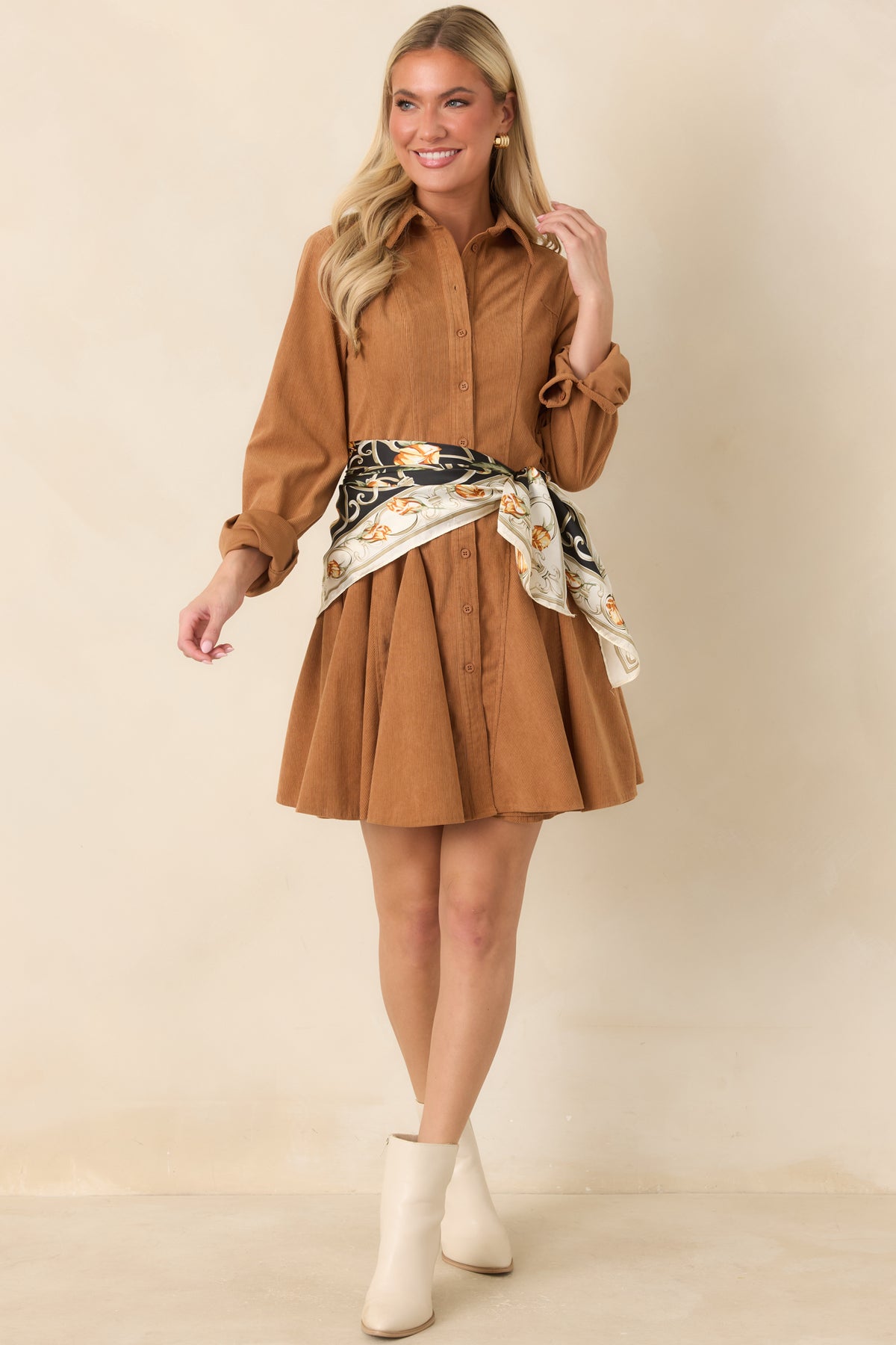 Fine corduroy texture and shaping seams define the golden camel dress with its long sleeves and button-front design.