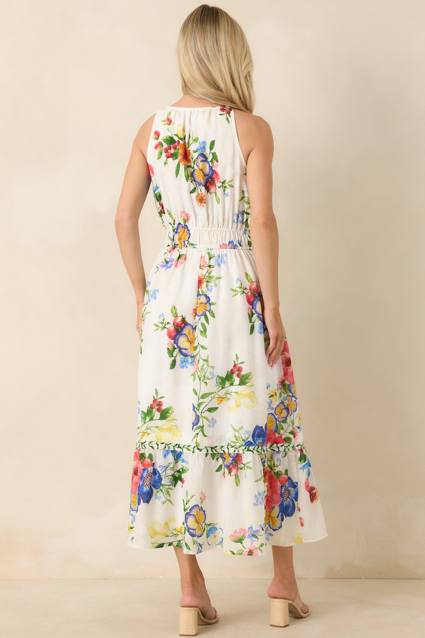 Rear view of floral and fruit print midi dress with elastic waistband and tiered hem movement.