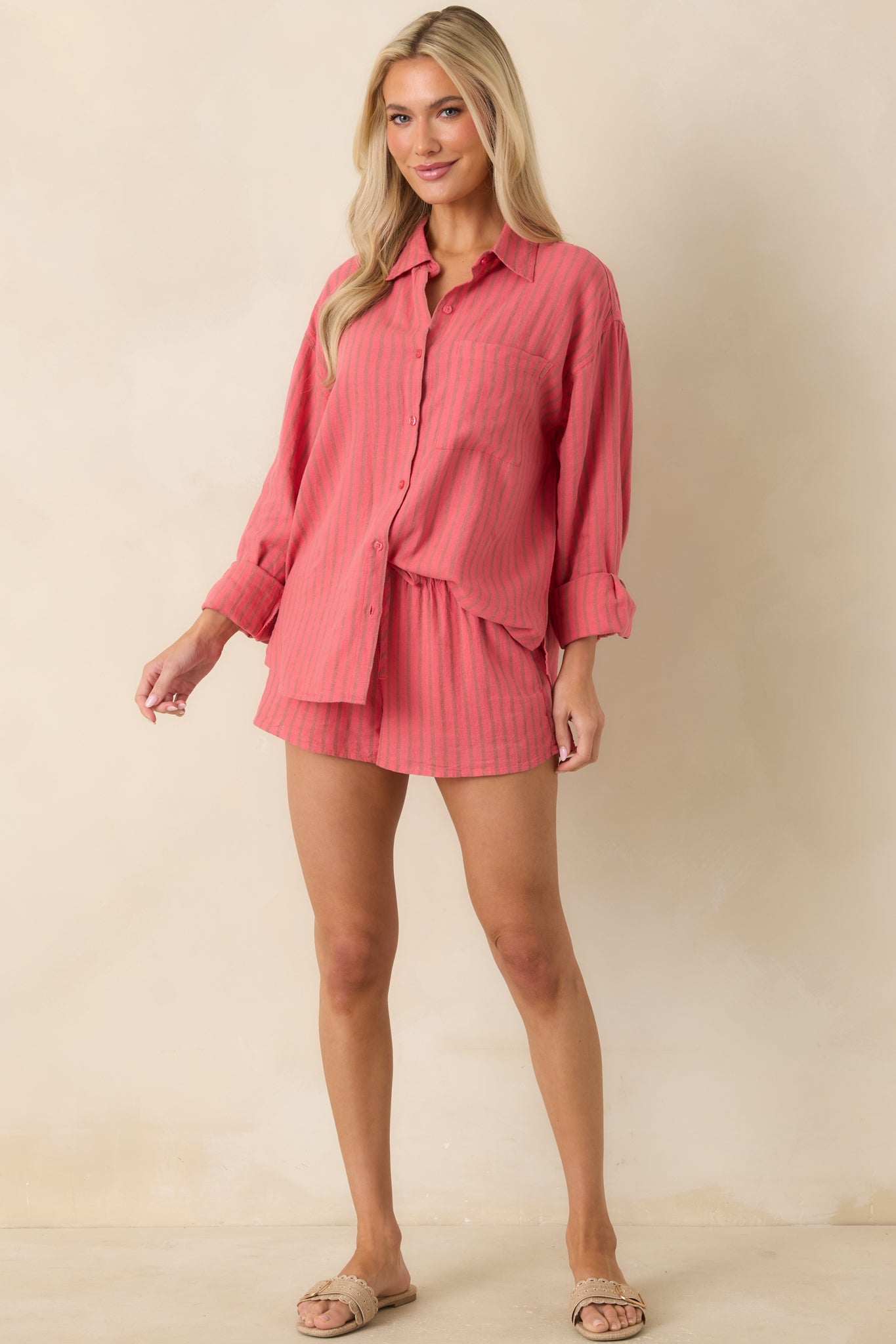 Lightweight coral pink shorts showcasing a relaxed shape, drawstring tie waist, and soft striped texture.